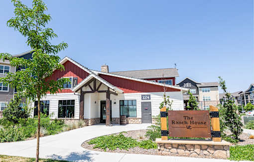 The Ranch House sign is in front of a building with a red roof.