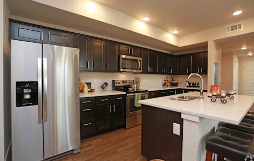 A modern kitchen with a white countertop and black cabinets.
