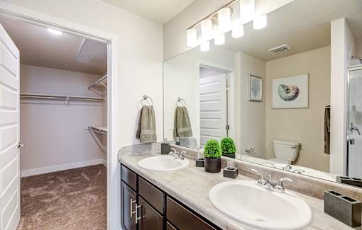 A bathroom with a sink, mirror, and towel rack.