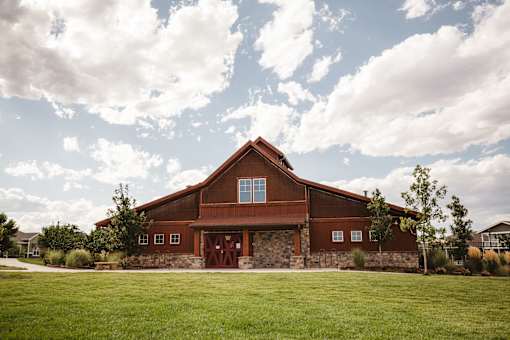 A barn with a red roof and a stone foundation.