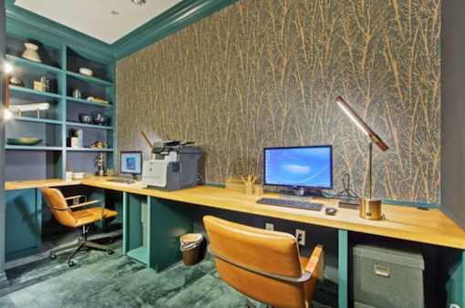 A computer desk with a blue screen monitor and a chair.