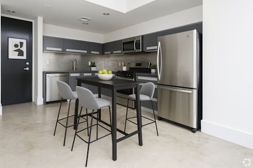 A kitchen with a table and chairs.