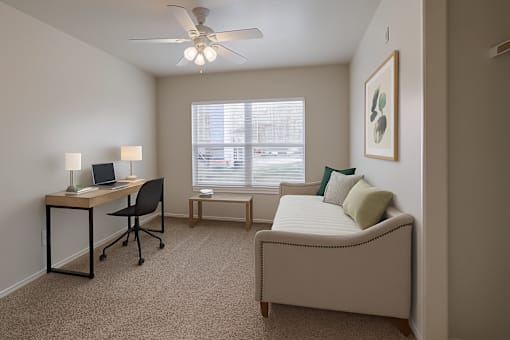 A room with a bed, desk, and chair.