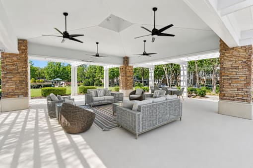 A patio with a white ceiling and a grey couch.
