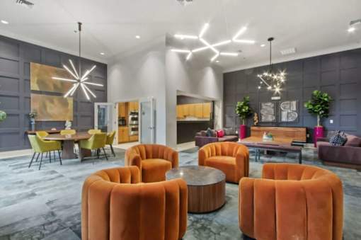 A modern living room with a grey wall and a large orange chair.
