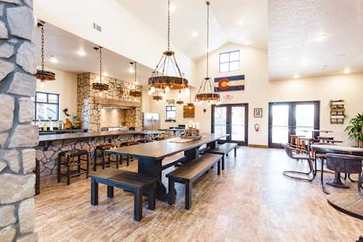 A large, well-lit room with a stone fireplace and wooden furniture.