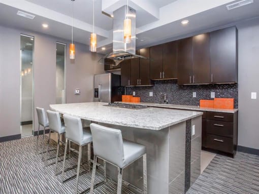 a large kitchen with a counter and chairs