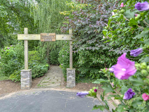 A wooden sign that says "Somerset Garden" is in front of a pathway.