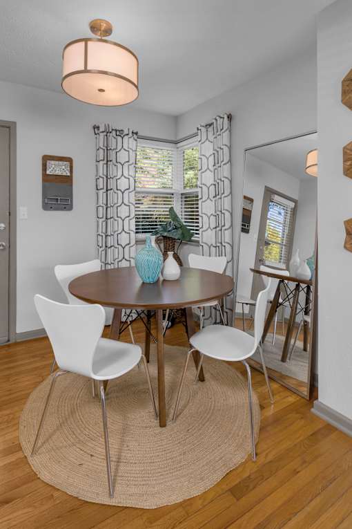 A dining room with a round table and chairs.