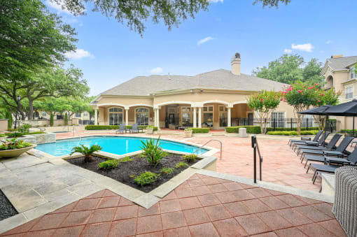 a house with a swimming pool and a patio with chairs