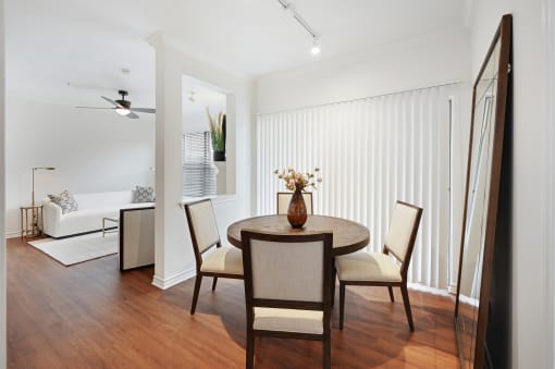 a living room and dining room with a table and chairs