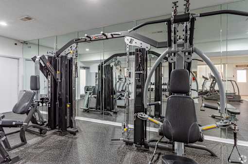 A gym with a variety of equipment including a leg press machine.