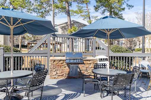 A patio with a table and chairs under umbrellas.