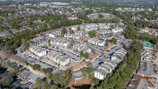 A bird's eye view of a residential area with houses and parked cars.
