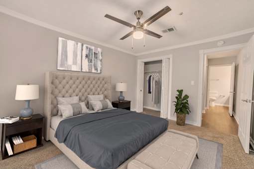 A bedroom with a large bed and a ceiling fan.