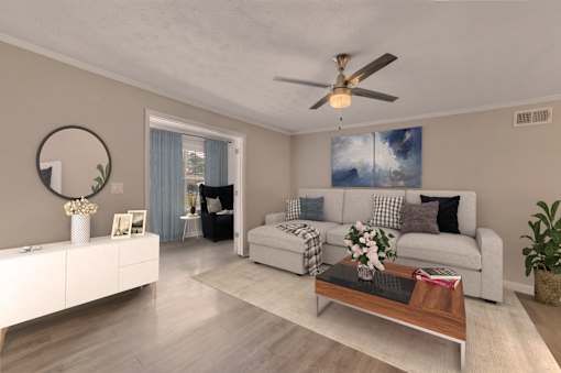 A modern living room with a white sofa, a coffee table, and a ceiling fan.