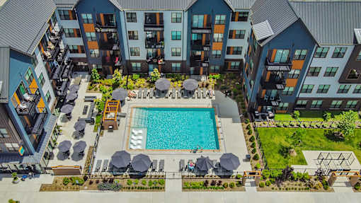 an overhead view of an apartment building with a swimming pool