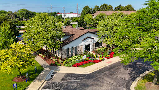 A house with a driveway and trees in front of it.