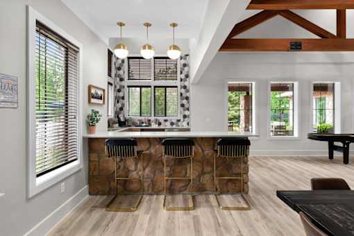 A kitchen with a stone counter and bar stools.
