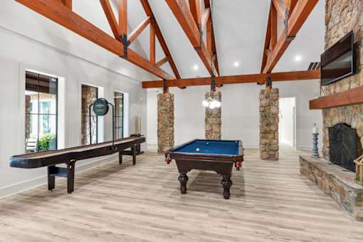 A room with a pool table and a fireplace.