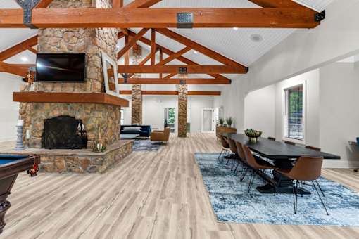 A large room with a fireplace and a long table.