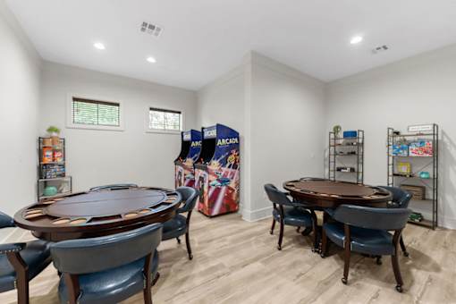 A game room with a poker table and chairs.