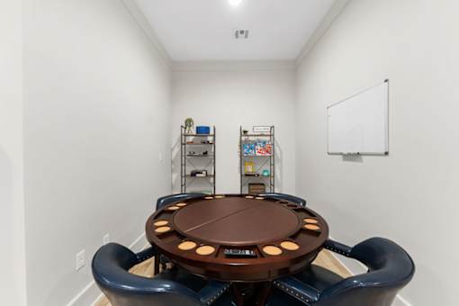 A conference room with a round table surrounded by chairs.