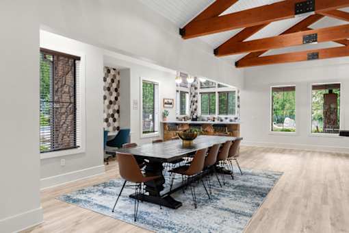 A dining room with a large table and chairs.