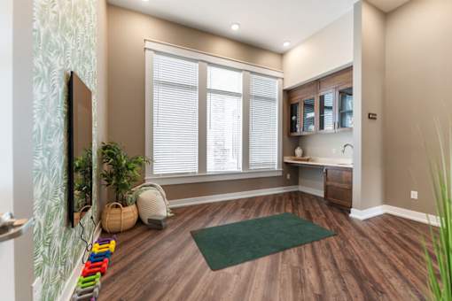 A room with a green rug and wooden floors.