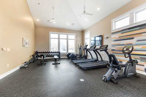 A spacious home gym with a variety of exercise equipment.