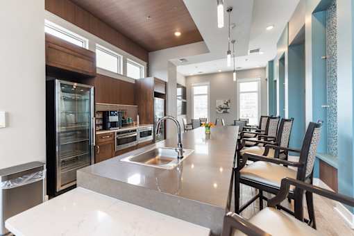 A modern kitchen with a large island and chairs.