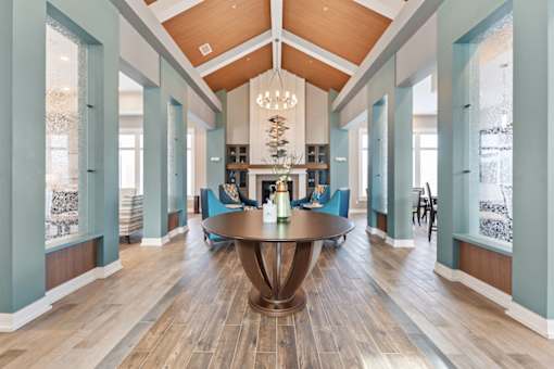 A large wooden table is in the middle of a room with blue walls and wooden floors.