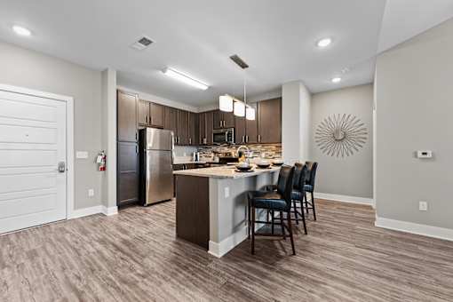 A modern kitchen with a wooden floor and a large island.