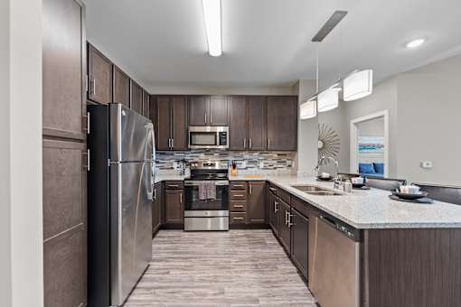 A modern kitchen with dark wood cabinets and stainless steel appliances.