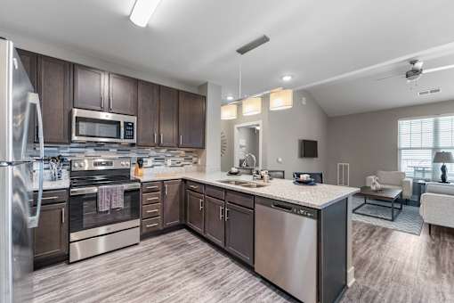A modern kitchen with stainless steel appliances and wooden cabinets.