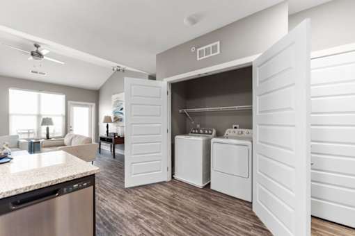 Luxury Apartments in Shawnee, KS with In-Unit Washer and Dryer - Bonavia Luxury Apartments - Laundry Closet with Storage Shelf and Full-Size Washer and Dryer.