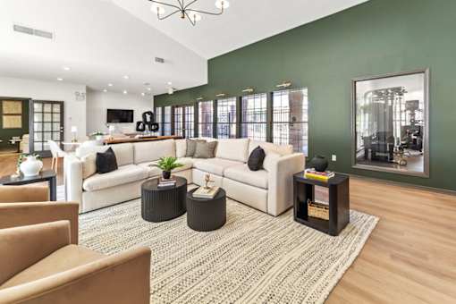 A living room with a white couch, a coffee table, and a rug.