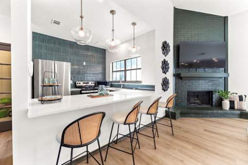 A kitchen with a bar area and a fireplace.