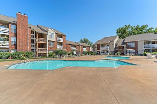 A large swimming pool in front of apartment buildings.