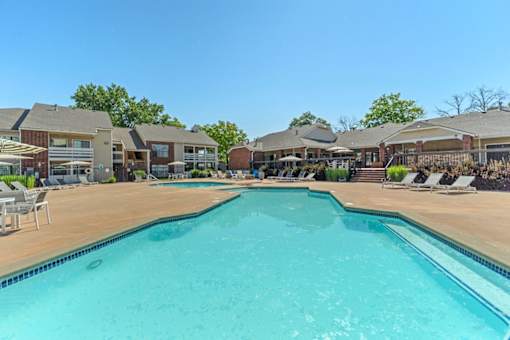 A large swimming pool in front of a resort.
