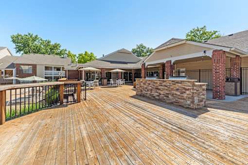 A wooden deck with a stone pillar and a brick pillar.