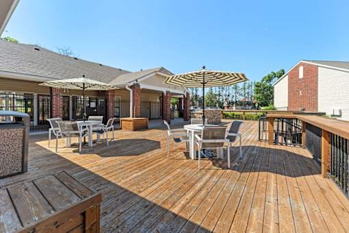 A wooden deck with chairs and an umbrella.