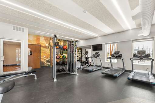 A gym with treadmills and a treadmill with a sign on it.