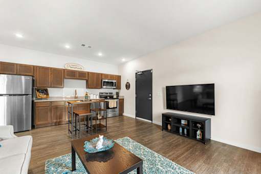 A modern kitchen with wooden cabinets and a black refrigerator.