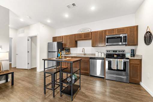 A kitchen with a wooden island and stainless steel appliances.