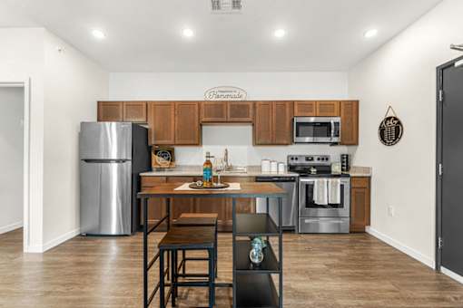 A kitchen with wooden cabinets and a black fridge.