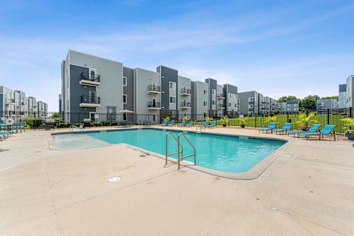 A swimming pool in front of apartment buildings.