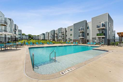 A swimming pool in front of apartment buildings.