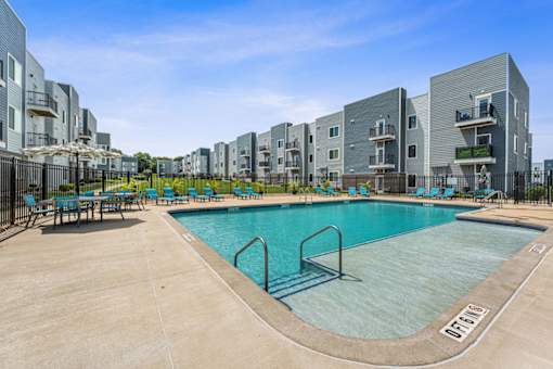 A swimming pool surrounded by apartment buildings.