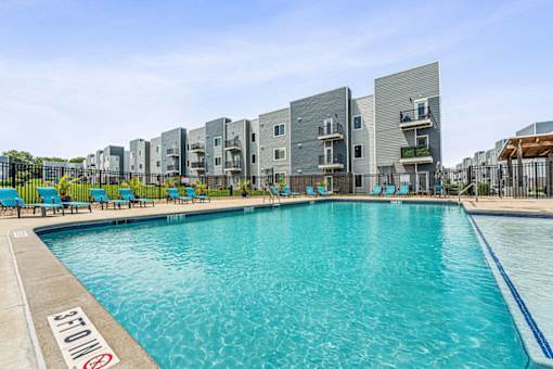 A swimming pool in front of apartment buildings.